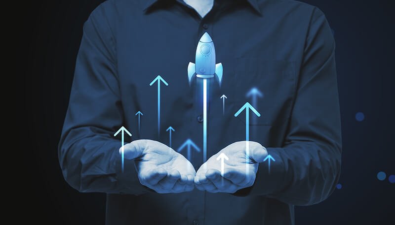 close-up-businessman-hands-holding-glowing-flying-blue-rocket-blue